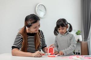 mutter unterrichtet tochter kind zähneputzen zu hause foto