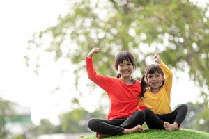 Kind spielt auf Spielplatz im Freien. kinder spielen auf dem hof der schule oder des kindergartens. aktives kind auf bunter rutsche und schaukel. gesunde sommeraktivität für kinder. kleines Mädchen, das draußen klettert. foto