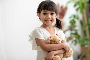 junge asiatische mutter, die haare der tochter bindet foto