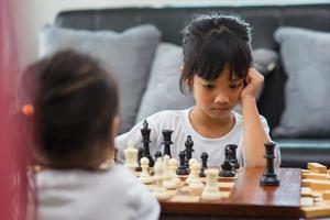 Zwei süße Kinder spielen zu Hause Schach foto
