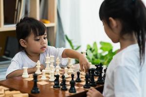 Zwei süße Kinder spielen zu Hause Schach foto