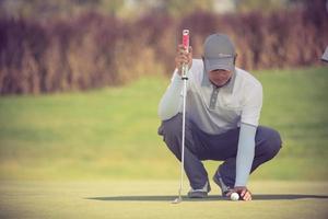 Profi-Golfspieler mit dem Ziel Schuss mit Schläger auf Kurs.Golfer auf Putting Green kurz vor dem Schlag foto