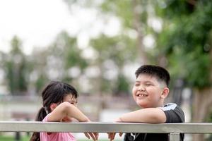 zwei kleine asiatische kinder junge und mädchen glücklich und lächeln im park foto