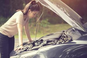 Frauen Spekulation Sie öffnete die Motorhaube kaputtes Auto auf der Seite sehen Motoren, die beschädigt sind oder nicht foto