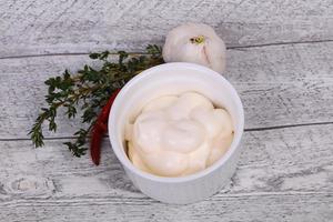 Mayonnaise-Sauce in der weißen Schüssel serviert Thymian und Knoblauch foto