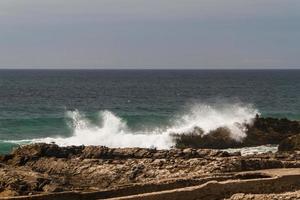 die wellen kämpfen um die verlassene felsige küste des atlantiks, portugal foto