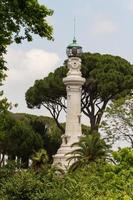 kleiner leuchtturm zwischen den bäumen in rom, italien foto