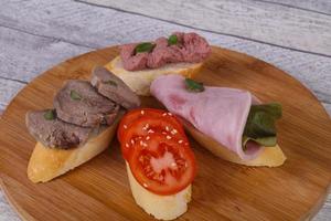 Bruschetta mit Tomate, Schinken und Zunge foto