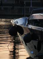 die untergehende sonne beleuchtet eine yacht im hafen von barcelona foto
