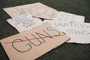 Sag Nein zu Waffen. Gruppe von Bannern mit verschiedenen feministischen Zitaten, die auf dem Boden liegen foto