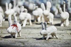 weiße kaninchenstatuen aus gips auf der kunstausstellung im freien, lustige weiße hasen auf der straße foto