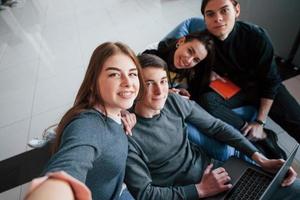 Lächeln Sie in die Kamera. Gruppe junger Menschen in Freizeitkleidung, die im modernen Büro arbeiten foto