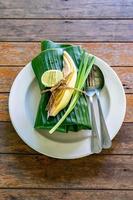 eingewickeltes thailändisches Essensset mit Bananenblatt, servierfertig. Im Inneren des Bananenblatts befindet sich Padthai, die traditionelle thailändische gebratene Nudel mit Garnelen. foto