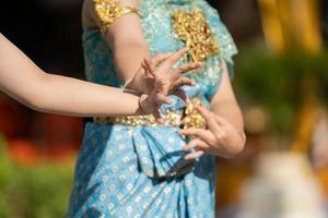 asiatisch - thailändische frauen tanzen im traditionellen thailändischen tanzstil mit türkisfarbenem vintage-kleid und golddekor auf ihrem kleid. foto
