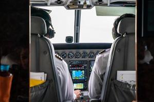 Nahaufnahme 2 Piloten steuern konzentriert den kleinen Privatjet am Himmel. foto