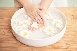 Spa-Behandlung und Produkt für weibliche Füße und Hand-Spa. Weiße Blumen in Keramikschale mit Wasser für die Aromatherapie im Spa. foto