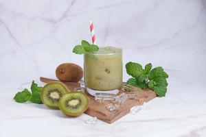 frische hausgemachte Kiwi-Smoothies mit Milch, Minze und Honig. Gesundes Bio-Getränk. Nahaufnahme und selektiver Fokus. frisch gemischte grüne früchte, wohlbefinden und gewichtsverlustkonzept. foto