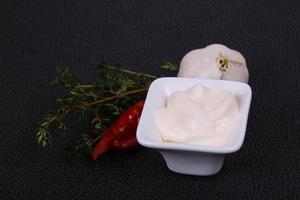 Mayonnaise-Sauce in der weißen Schüssel serviert Thymian und Knoblauch foto