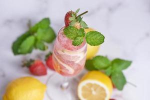 Zitronen- und Erdbeerlimonade Minze frisch hausgemacht im Glas, sommerlicher kalter Cocktail, Erdbeer-Zitronen-Limetten-Mojito, heller Hintergrund, Kopierraum, ein erfrischendes Sommergetränkekonzept. foto