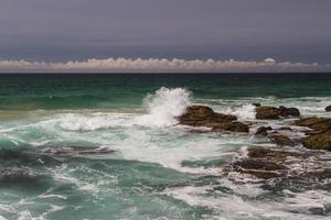 die wellen kämpfen um die verlassene felsige küste des atlantiks, portugal foto