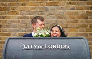 frisch verheiratetes paar verschiedener nationalitäten für ein vorhochzeitsfotoshooting in london. der mann ist britische asiatische frauen foto