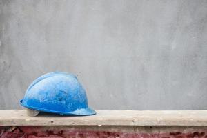 Blauer Schutzhelm auf Hausbau-Baustelle foto