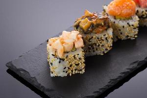 Sushi rollt auf einer Steinplatte