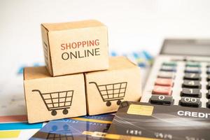 Online-Shopping-Box mit Kreditkarte und Taschenrechner im Diagramm. Geschäftskonzept für Finanzen, Handel, Import und Export. foto