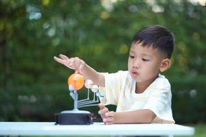 asian boy living solar system toys, home learning equipment, während neuer normaler Veränderungen nach dem Coronavirus oder einer Pandemie nach dem Ausbruch von Covid-19 foto