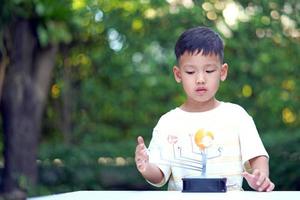 asian boy living solar system toys, home learning equipment, während neuer normaler Veränderungen nach dem Coronavirus oder einer Pandemie nach dem Ausbruch von Covid-19 foto