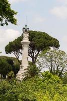 kleiner leuchtturm zwischen den bäumen in rom, italien foto