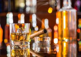 Whiskygetränk mit rauchender Zigarre an der Bar