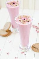 rosa Erdbeer-Smoothie mit braunen Keksen auf hellbraunem Rusti foto