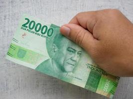 den Wert von 20.000 Rupiah in indonesischer Währung halten foto