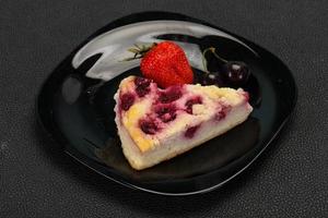 Käsekuchen mit Kirsche, serviert mit Erdbeeren foto