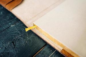 Handgefertigter Notizbuch-Organizer aus Leder auf dunklem Holzhintergrund foto
