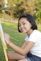 Asiatisches kleines Mädchen, das im Park malt foto