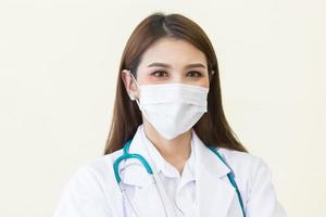 asiatische Ärztin stand in einem weißen Gewand, trug eine Maske und ein Stethoskop. Gesundheitsversorgung, Umweltverschmutzung pm2.5, neues Normal- und Coronavirus-Schutzkonzept. foto