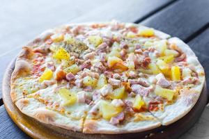 hawaiianische pizza ist ein italienisches essen, das aus tomatensauce, gehackter ananas, schinken und käse zubereitet wird. foto