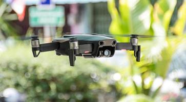 Niemand, moderne Drohne mit 4 Propellern hat 4k-Kamerafoto und -video, die in der Stadt fliegen. das konzept für profis in der industrie der unbemannten flugzeugtechnik. Nahaufnahme und Ernte, unscharfer Hintergrund foto