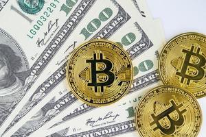 Bitcoins-Münze und Banknoten von hundert Dollar foto