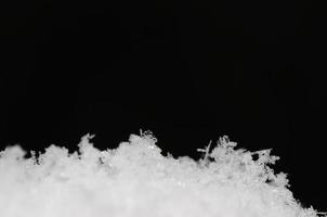 frische kristalle im schnee auf schwarz foto