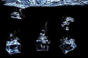 Eiswürfel im Wasser auf dunklem Studiohintergrund. das Konzept der Frische mit Kühle aus Eiswürfeln. foto