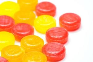 medizinische Pastillen zur Linderung von Husten, Halsschmerzen und Halsreizungen isoliert auf weißem Hintergrund. Husten und Schnupfen fallen. bunte Hustenpastillen. rote, orange und gelbe runde Bonbons oder Bonbons. foto