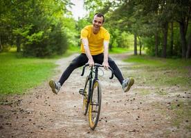 Porträt eines jungen Mannes, der sich auf einem Fahrrad fortbewegt. foto