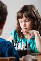 Mädchen und Junge spielen Schach