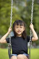 junges asiatisches Mädchen, das glücklich im Park spielt foto