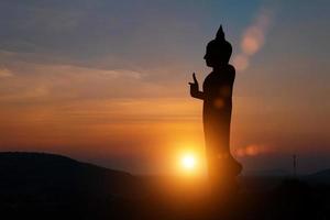 Silhouette der Buddha-Statue bei Sonnenuntergang Himmelshintergrund. Konzept der buddhistischen Feiertage. foto