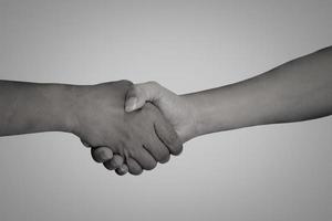 Hände nehmen das Handgelenk auf einem monochromen Foto. konzept der freundschaft, partnerschaft, hilfe und hoffnung anderer. foto