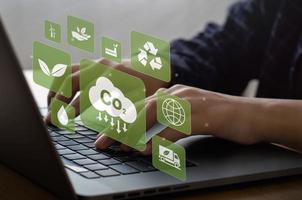 Konzept zur Reduzierung der Umweltenergie. CO2-Emissionen mit Symbolen für die globale Erwärmung. mit Geschäftsleuten, die Computer tippen foto